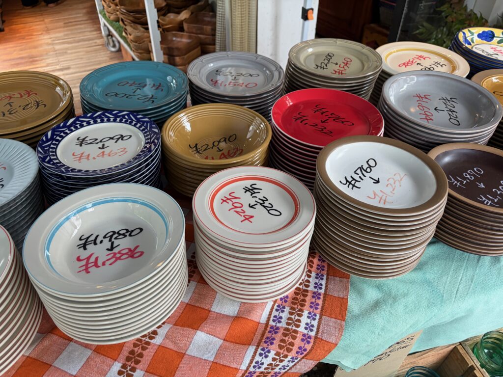 値下げ札が付いた大皿がぎっしり積まれた店頭コーナー