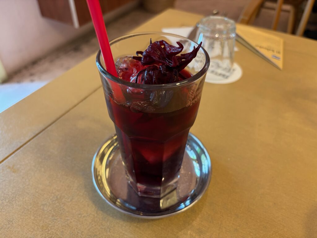 ハイビスカスのドリンク「ハマイカ」。花が浮かんだ赤紫のグラス