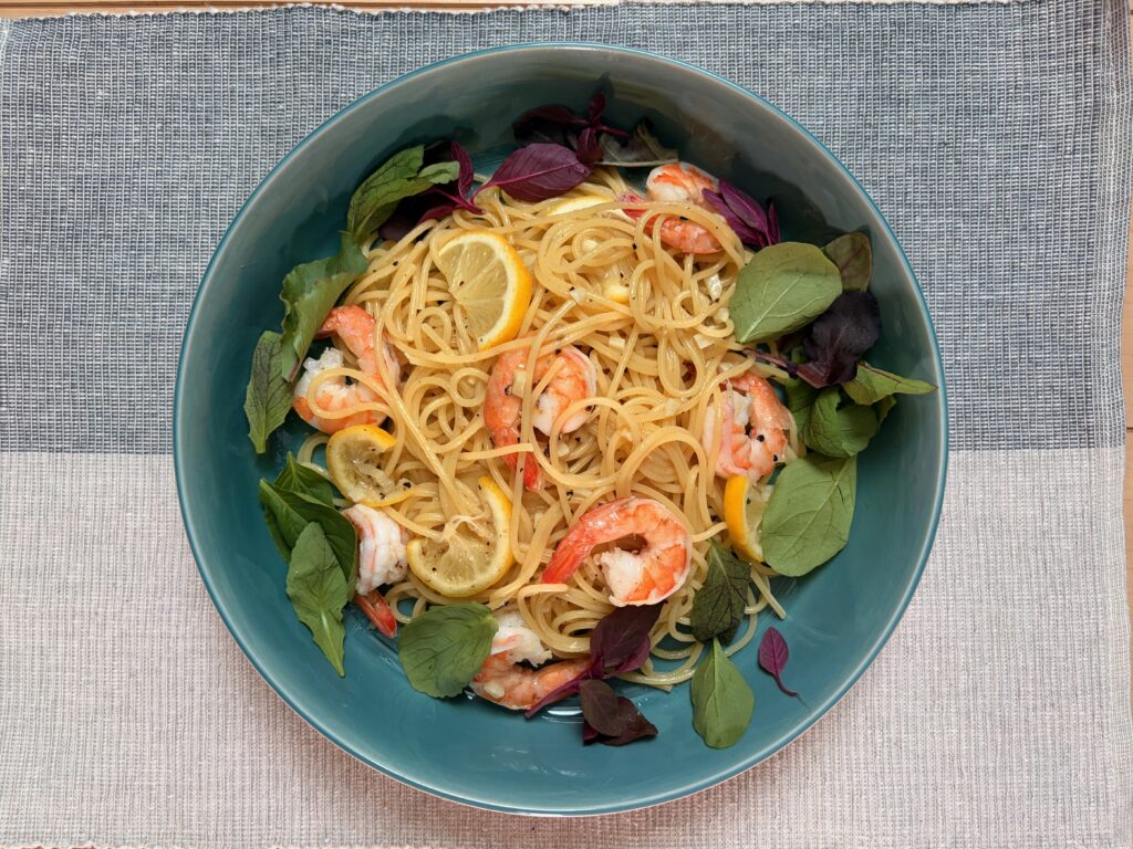 ターコイズの器に盛り付けたエビとレモンのパスタを真上から撮影